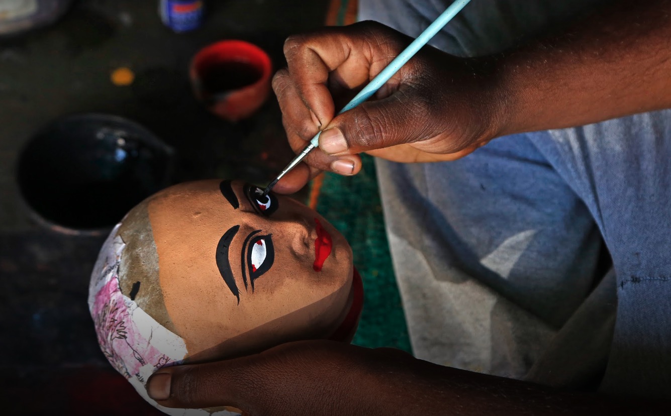 Artisan hand-painting a traditional mask