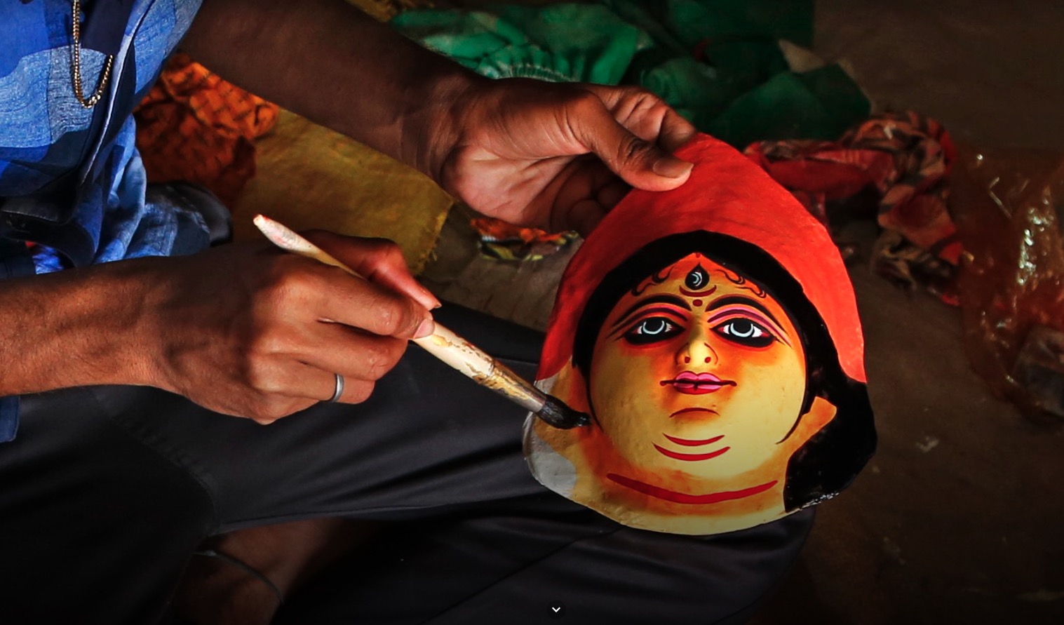 Artisan painting a traditional Chhau mask by hand